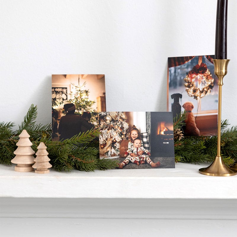 Holiday photo cards on a decorated mantle